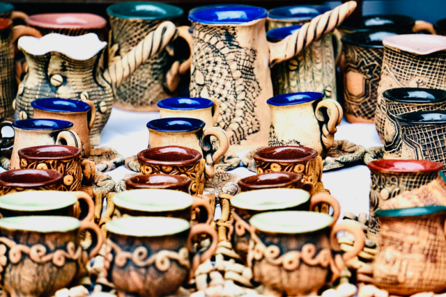 Căni de ceramică lucrate de mână, expuse pe o tarabă din piață